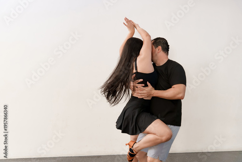Фотография Passionate couple dancing bachata at dance school