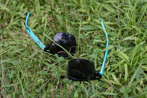 A pair of broken sunglasses laying in the grass