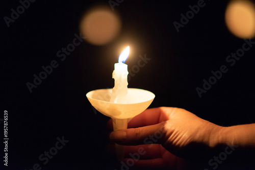 Hand holding a candle during a candlelit service
