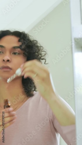 Vertical video: Selecting person in pink top at vanity using amber dropper for skincare under eyes