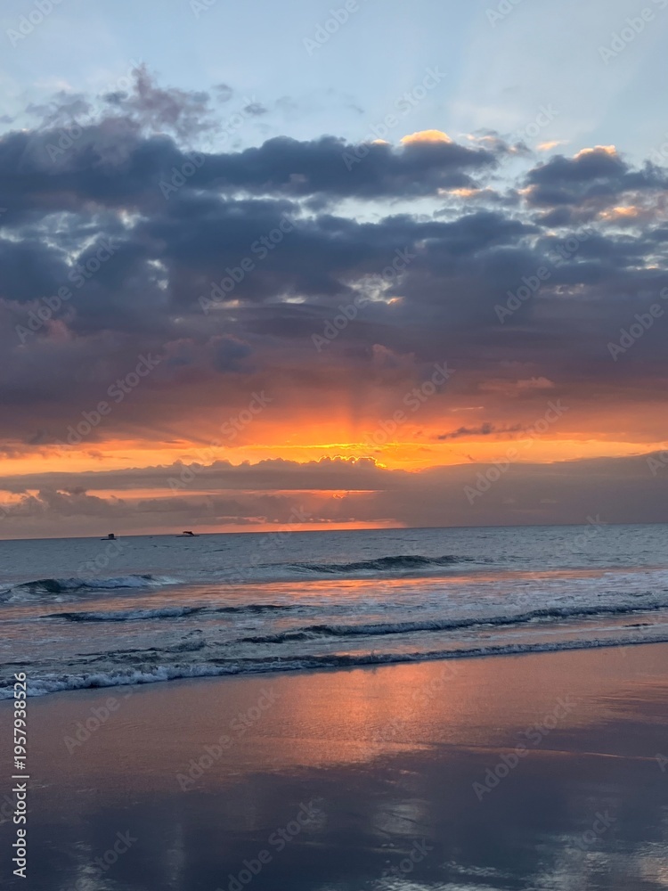 Fototapeta premium Colorful sunset over ocean waves with dramatic sky