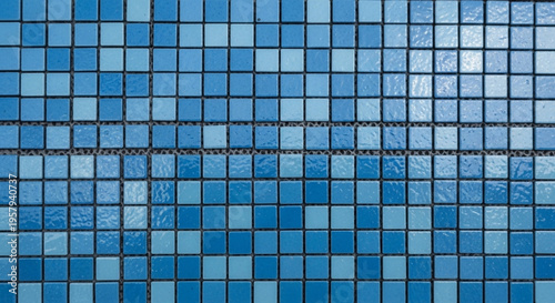 Grid pattern of small, square ceramic mosaic tiles in various shades of blue and cyan, commonly used for swimming pools or bathrooms.