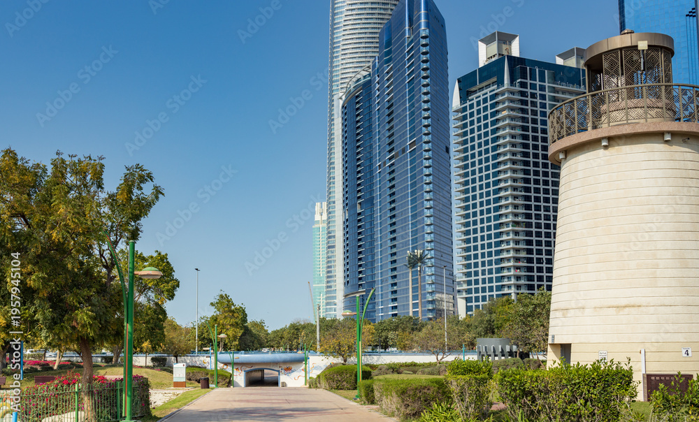 Obraz premium Modern towers rise beside a historic lighthouse