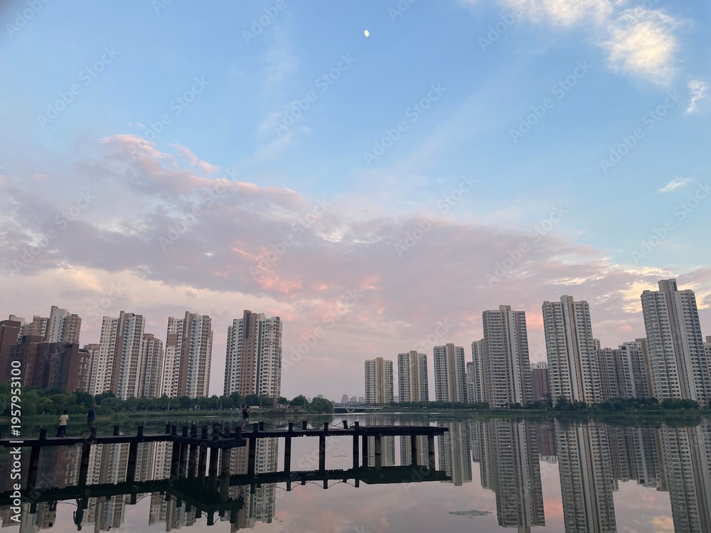 Obraz premium Cityscape Lake reflection High-rise apartments Sunset sky Moon Boardwalk