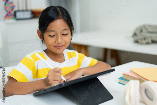 Asian girl writing on digital tablet with stylus pen for online learning