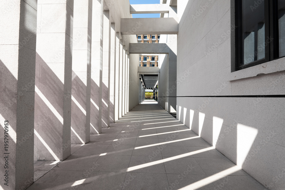 Naklejka premium Modern architectural corridor with intersecting light and shadow patterns