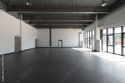 Konstfotografi Spacious industrial-style indoor space with exposed ceiling pipes and large wind