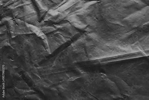 Crumpled Black Plastic Texture Background with Detailed Creases for Dark Design Backdrop