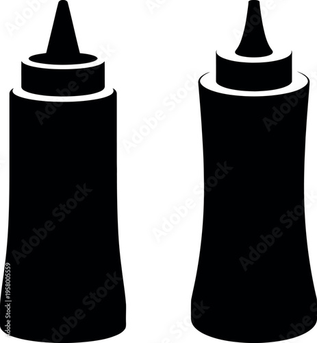 Two black condiment bottles with pointed caps standing side by side