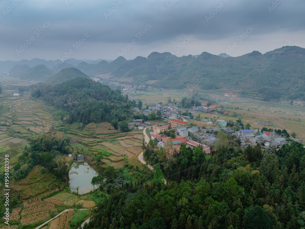 Obraz premium Aerial view of rice terraces in the mountains of Quan Ba, Ha Giang, Vietnam. The terraces are used to grow rice, a staple food . The mountains provide a scenic backdrop.