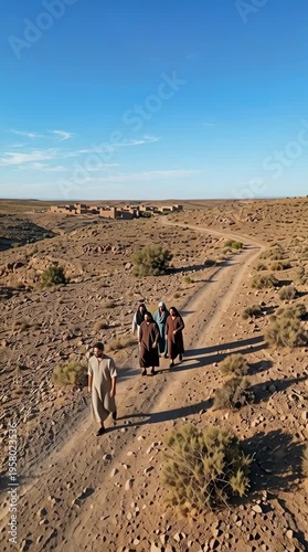 Followers walking along rugged dirt path to remote desert vertical video