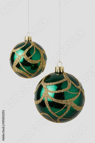 Green Christmas Baubles with Gold Floral Pattern Hanging on Light Background