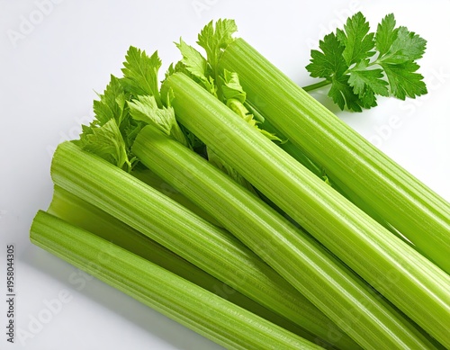 Fresh Green Celery Stalks with Leaves on a White Background.