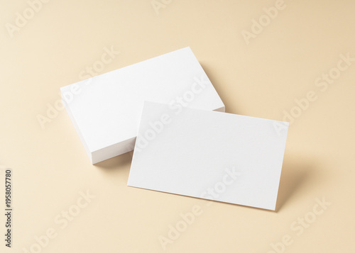 Blank white business cards mockup on beige background with soft shadows