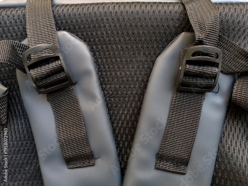 Close-up of gray backpack straps and buckles on textured fabric