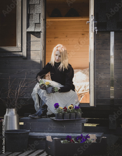 Woman planting pansy flowers in garden