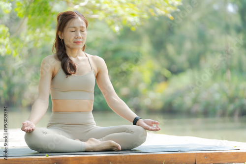 Fotografi Asian woman yoga meditation outdoor nature calm river park scene where fitness p