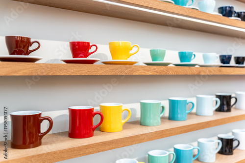 Photos Colorful Ceramic Coffee Cups including red, yellow, green, cyan, black and white Displayed on Wooden Shelves in Store