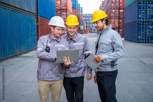 Engineer industrial workers males teamwork using laptop and tablet in shipping container yard logistics