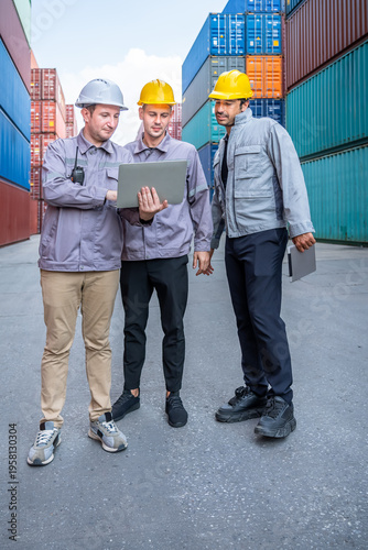 Engineer industrial workers males inspecting logistics using laptop and tablet in shipping container yard