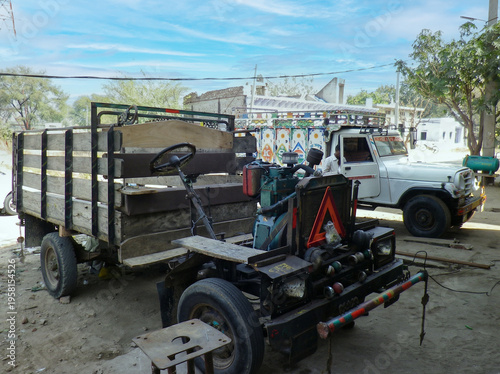 Rusty flatbed trailer beside white pickup truck