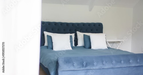 Motor is moving sliding door panel, revealing tufted headboard and queen-size bed for room showcase