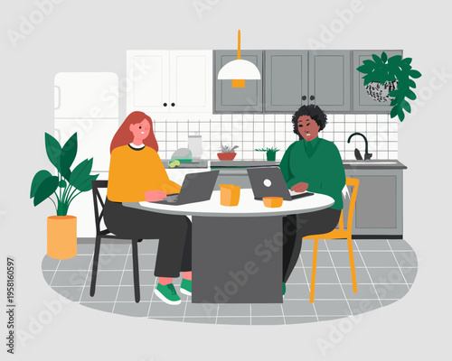 Two women collaborate on laptops at a kitchen table