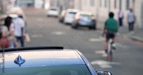 Diverse pedestrians passing by and cyclist riding street with camera locked on blue car roof rack