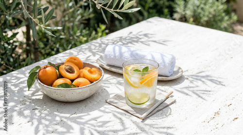 Summer reset concept with a cold face towel and citrus water on the table outside in the garden with fresh fruits nearby during a sunny day