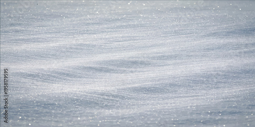 A detailed shot of freshly fallen snow, with its delicate texture and subtle waves, evoking a sense of tranquility. 