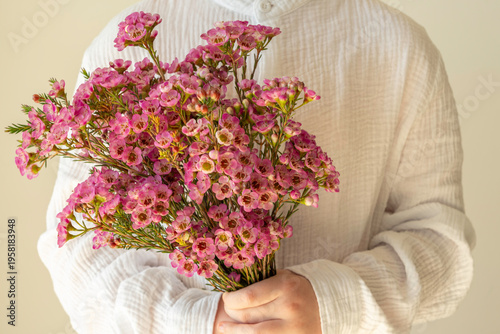 Holiday background with Myrtle flower bouquet in the hands of a child.
