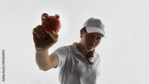 Female cricket player holding cricket ball toward camera isolated on white background. Concept of sports advertising banners, promotional campaigns, brand messaging, copy space design.