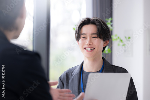 仕事での面談やキャリアカウンセリングなど対面で面接する爽やかなビジネスイメージ　デザイナーやエンジニア、マーケターなどクリエイティブ職のインターンなど新卒の若い男性