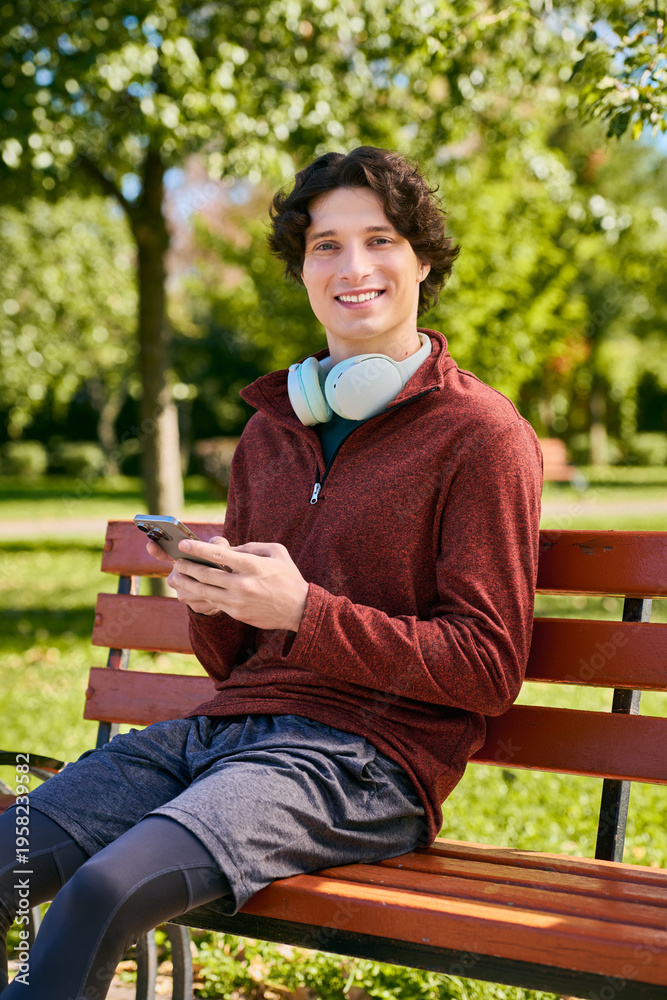 Fototapeta premium Young man in stylish outerwear enjoys a spring day while relaxing outdoors