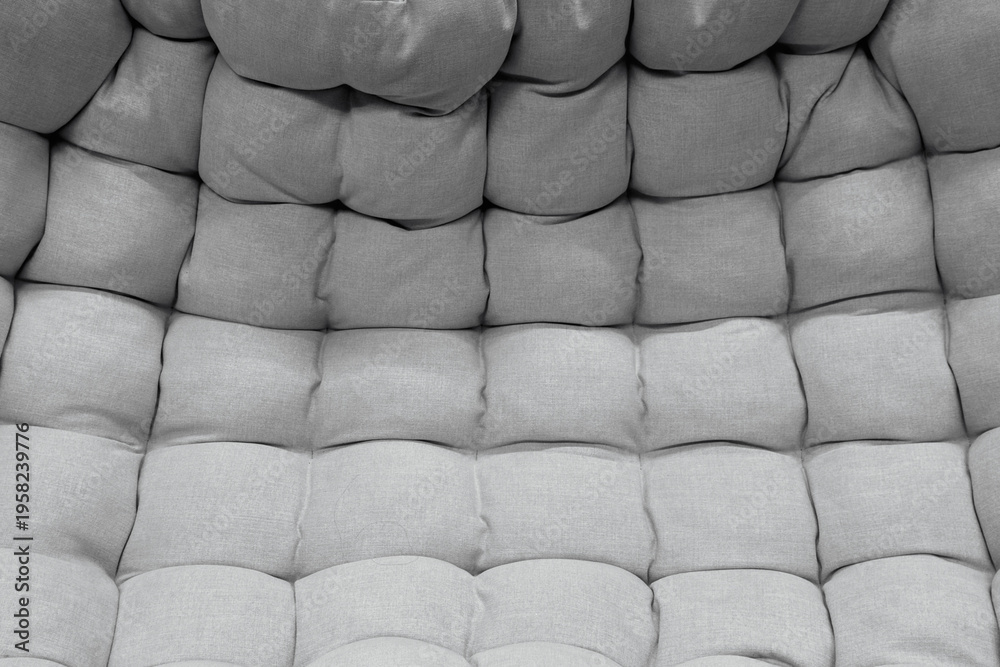Fototapeta premium Textured grey upholstery with rounded padded squares showing gradient effect