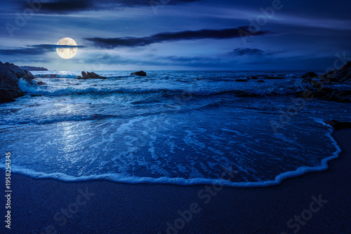 mysterious sandy sea beach at night. full moon over scene on cold summer vacation season. beautiful view of waves washing the sand. generic image of seascape and sky for advertising background