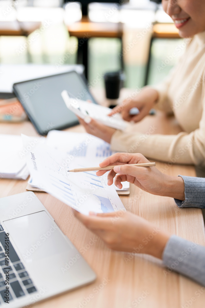 Fototapeta premium Business team hands analyzing financial growth charts and using calculator during strategy planning at a modern wooden desk in office.