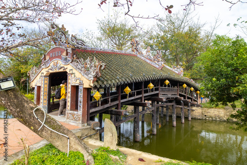 View of the ancient Thanh Toan bridge, with its weathered wooden structure and ornate roof, standing gracefully over the tranquil waters, Huong Thuy, Vietnam.