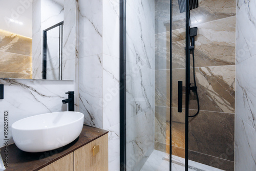 Stylish marble bathroom featuring black accents and lighting