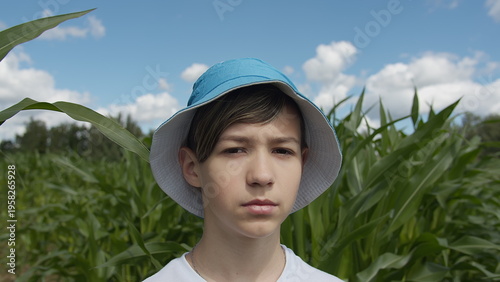 Foto Young Boy Wearing Hat Standing in Cornfield on Sunny Day, have fun and enjoy