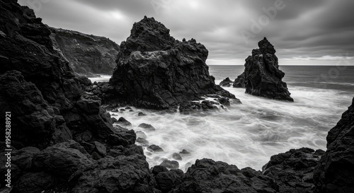 Dramatic Black and White Seascape: Jagged Rocks, Turbulent Waters, and Moody Sky