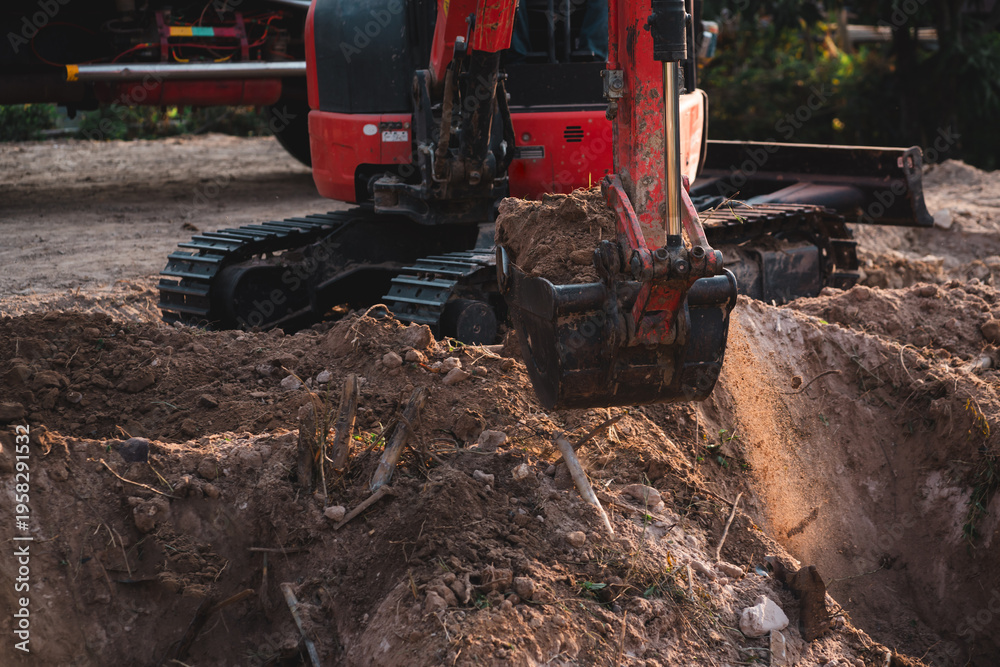 Fototapeta premium Excavator digging soil at construction site. Building foundation and infrastructure project