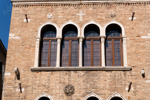 Characteristic Venetian gothic windows placed on the facade of a historic building in Venice. Venice, Italy