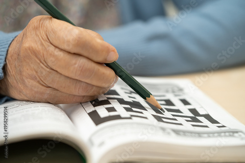 Asian elderly woman playing puzzle game.