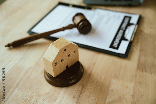 Gavel placed on a real estate contract with house model and pen, representing property law, legal agreements, and housing transactions.