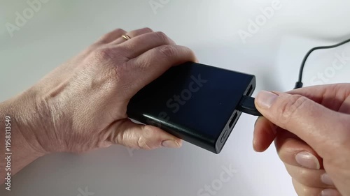 Power bank in woman’s hands, turning on and off