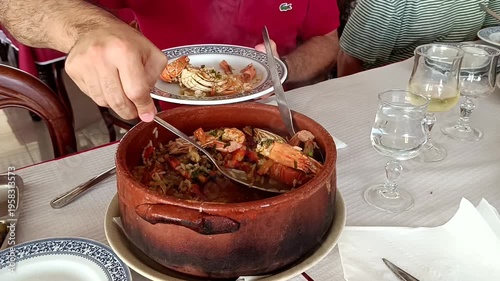 Typical portuguese dish rice with seafood in big brown ceramic pot