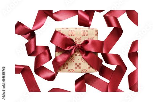 A square gift box, wrapped with patterned paper and a red satin bow, is surrounded by flowing red ribbon against a white background. Perfect for holidays and celebrations