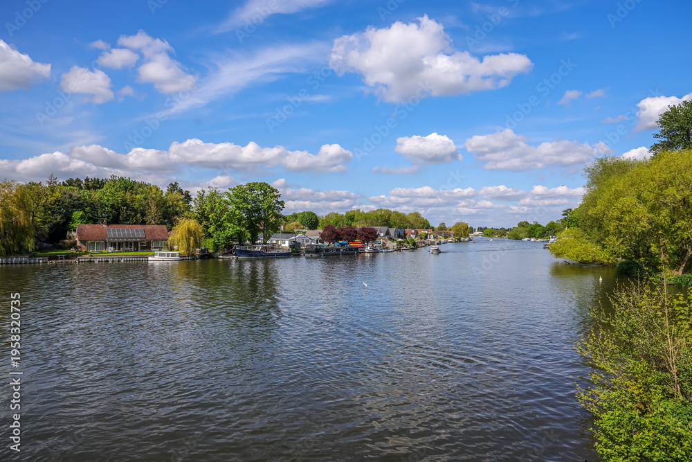 Fototapeta premium View of riverbank of River Thames on a clear spring day, Walton-on-Thames, England, UK. Walton-on-Thames, known locally as Walton, is a market town on the south bank of the Thames in northwest Surrey,