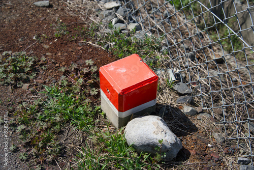 Photography Red and white concrete boundary marker on ground